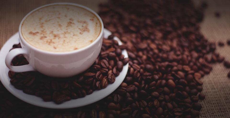 A cappuccino among coffee beans