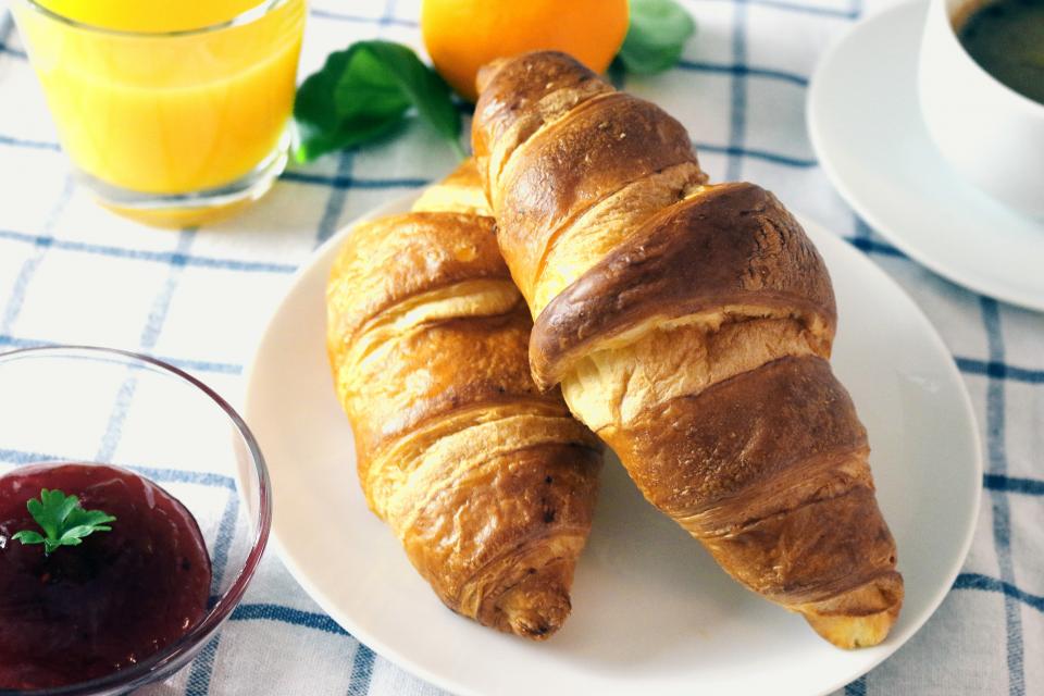 Croissants, jam and orange juice on a table
